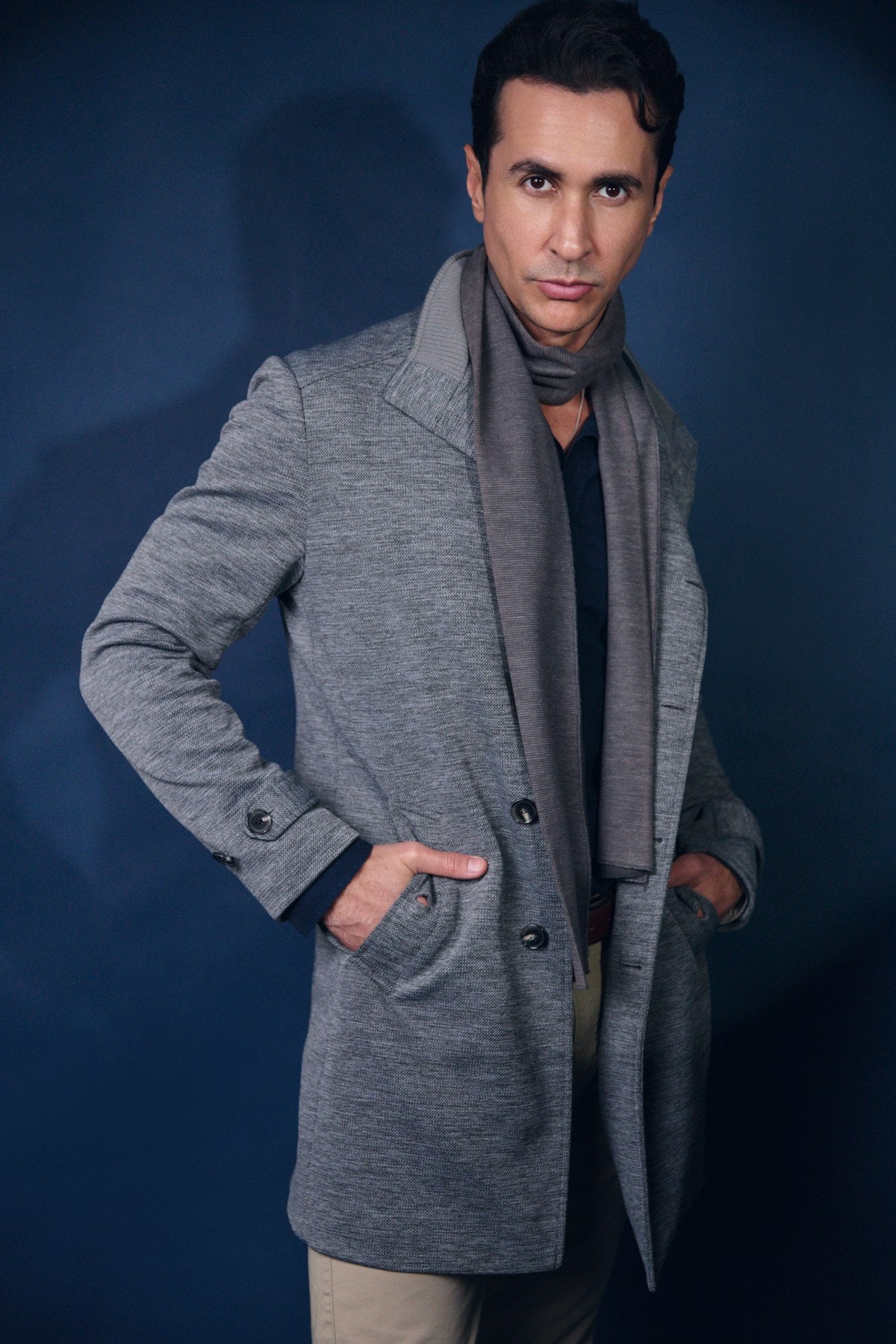 Uomo con cappotto grigio e sciarpa